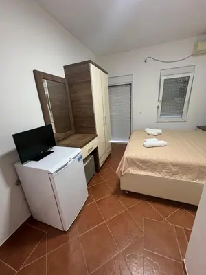 a small room with two beds and a refrigerator at Apartments DIJAR in Ulcinj