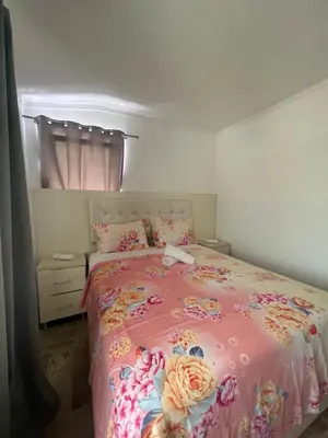 a bedroom with a pink bed with flowers on it at Apartments DIJAR in Ulcinj