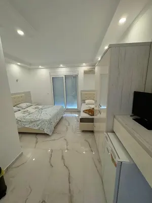 a bedroom with two beds and a tv on a marble floor at Apartments DIJAR in Ulcinj
