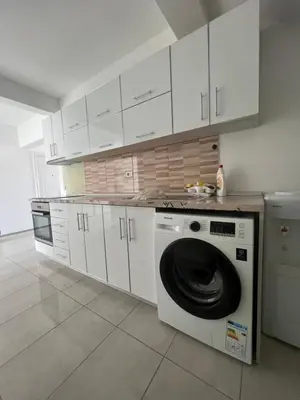 a kitchen with a washing machine and white cabinets at Apartments DIJAR in Ulcinj