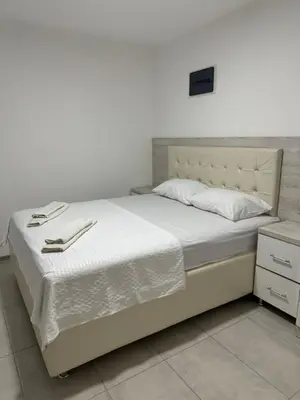 a bedroom with a white bed with white sheets at Apartments DIJAR in Ulcinj