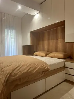 a bedroom with a large bed with a wooden headboard at Monte Budva in Budva