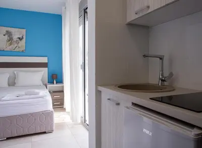 a kitchen with a sink and a bed in a room at Vila Kalina Apartments in Sutomore