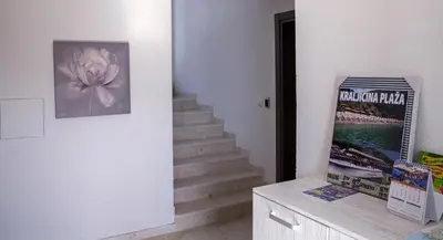 a hallway with a staircase with a flower on the wall at Vila Kalina Apartments in Sutomore