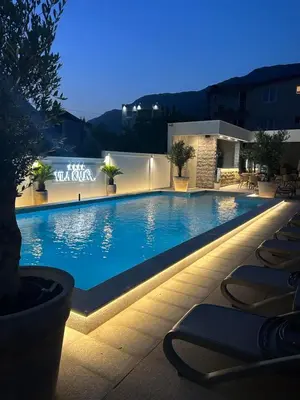 a large swimming pool at night with lounge chairs at Vila Kalina Apartments in Sutomore