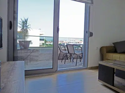a living room with a sliding glass door leading to a patio at Apartmani Hamburg 1 in Donji Štoj
