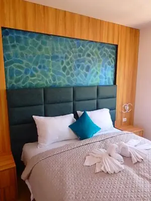 a bedroom with a bed with a large headboard at Apartmani Hamburg 1 in Donji Štoj