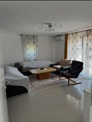 a bedroom with a bed and a chair and a table at huzur ve güven in Podgorica