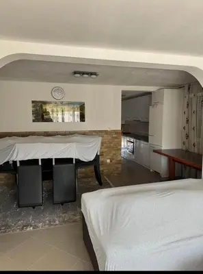 a living room with a table and a kitchen at huzur ve güven in Podgorica