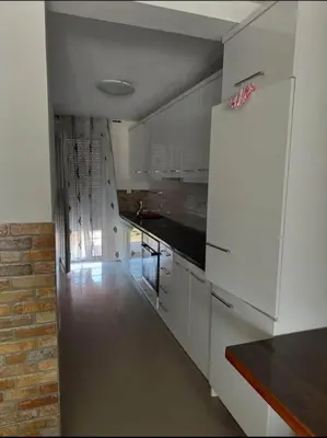 a kitchen with white cabinets and a refrigerator at huzur ve güven in Podgorica