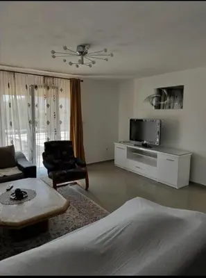 a living room with a bed and a couch and a tv at huzur ve güven in Podgorica