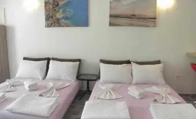 two beds in a room with paintings on the wall at Apartments Masa in Sutomore
