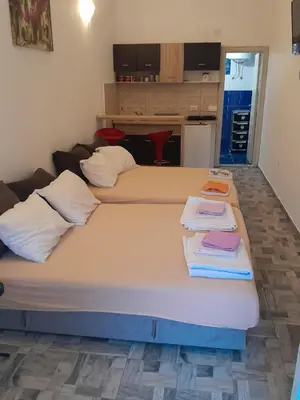 two beds in a room with towels on them at Apartments Masa in Sutomore