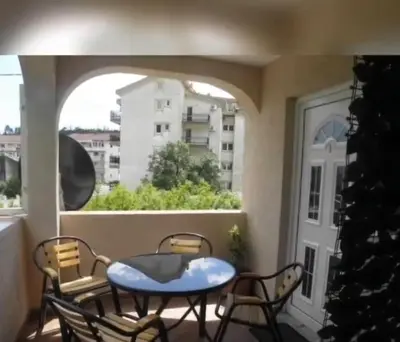 a balcony with a table and chairs and a window at Apartments Masa in Sutomore