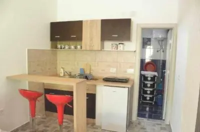 a kitchen with two red bar stools and a counter at Apartments Masa in Sutomore