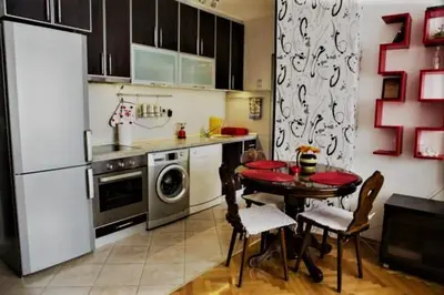 a kitchen with a table with chairs and a refrigerator at Apartment Tea in Cetinje