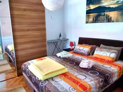 a bedroom with a large bed with colorful pillows at Apartment Tea in Cetinje