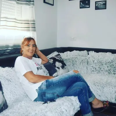 a woman sitting on a blanket on a couch at Apartment Tea in Cetinje