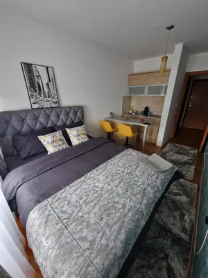 a bedroom with a large bed and a kitchen at Riverview in Podgorica