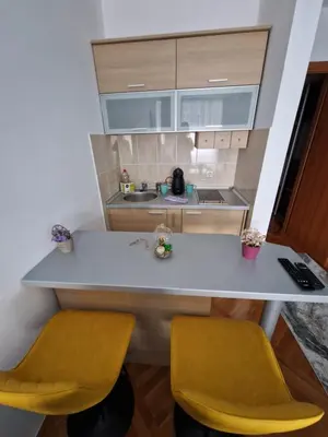 a kitchen with two yellow chairs and a counter at Riverview in Podgorica