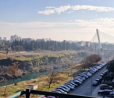 a long line of cars parked next to a bridge at Riverview in Podgorica