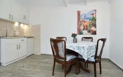 a kitchen with a table and chairs in a kitchen at One bedroom apartment Old town in Budva