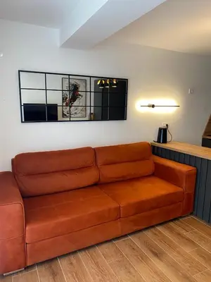 a brown leather couch in a living room at Апартаменты Hygge in Dobra Voda