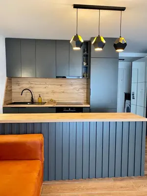 a kitchen with a counter with a sink and some lights at Апартаменты Hygge in Dobra Voda
