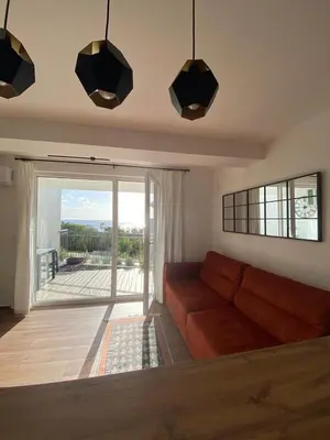 a living room with a couch and a large window at Апартаменты Hygge in Dobra Voda