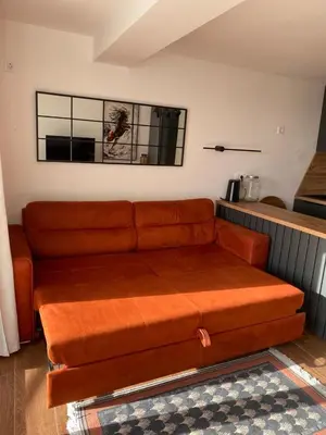 a brown couch sitting in a living room at Апартаменты Hygge in Dobra Voda