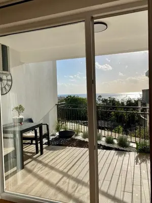 a sliding glass door with a view of a balcony at Апартаменты Hygge in Dobra Voda