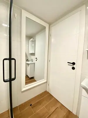 a bathroom with a door with a mirror and a sink at Апартаменты Hygge in Dobra Voda