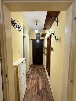 a hallway with a black door and wooden floors at Coasthouse Budva in Budva