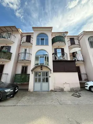 a large white building with a blue door and windows at Coasthouse Budva in Budva