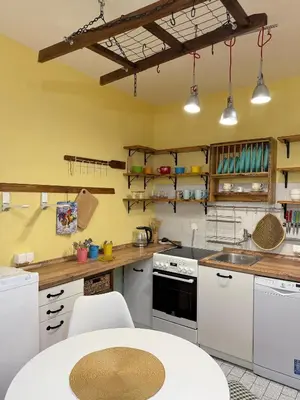 a kitchen with white appliances and a table in it at Coasthouse Budva in Budva