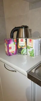 a counter with a tea pot and two boxes on it at Enjoy Apartmani in Podgorica