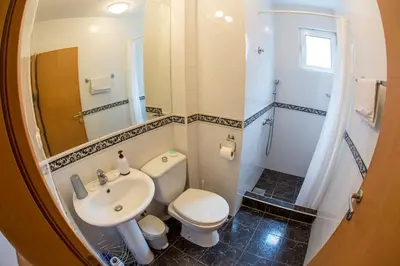 a bathroom with a white toilet and a sink at Apartments Luka in Budva