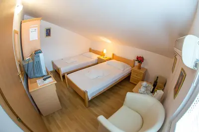 a small room with two beds and a chair at Apartments Luka in Budva
