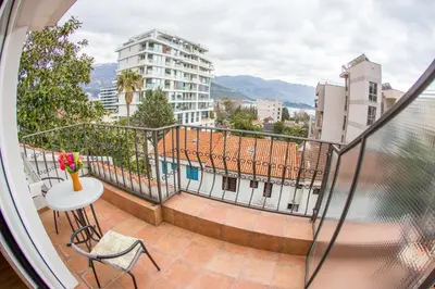 a balcony with a table and chairs and a building at Apartments Luka in Budva