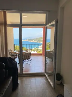 a living room with a glass door leading to a balcony at Apart Bella Utjeha Sea View 68 qm in Utjeha
