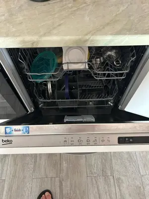 a dishwasher with its door open and a person standing on the floor at Apart Bella Utjeha Sea View 68 qm in Utjeha