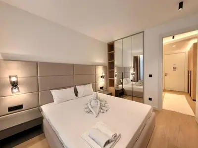 a bedroom with a white bed with towels on it at Air Onia in Budva