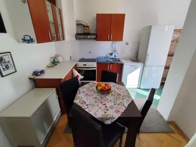 a small kitchen with a table with a bowl of fruit on it at HarmonyHome in Podgorica