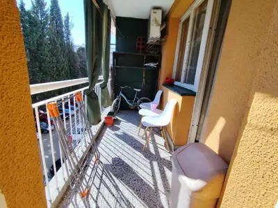 a balcony with two white chairs and a window at HarmonyHome in Podgorica