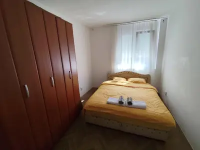 a small bedroom with a bed with two shoes on it at HarmonyHome in Podgorica