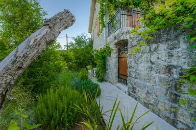 an old stone building with a stone wall and plants at Mediteraneo Villa in Kaluđerovići