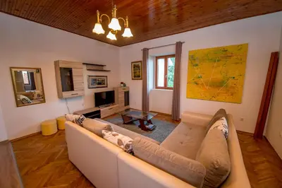 a living room with a couch and a tv at Mediteraneo Villa in Kaluđerovići