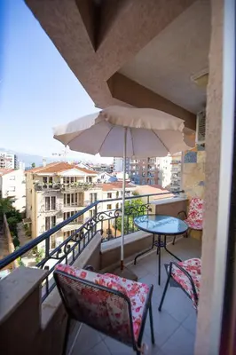 a balcony with a table and chairs and an umbrella at Central Budva M Lux Apartments in Budva