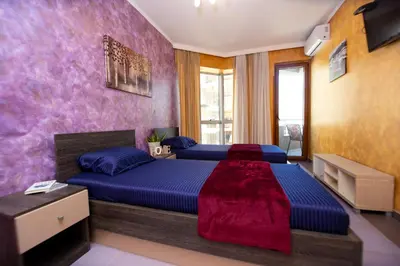 a bedroom with two beds and a purple wall at Central Budva M Lux Apartments in Budva