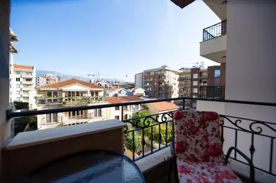 a balcony with a chair and a view of a city at Central Budva M Lux Apartments in Budva